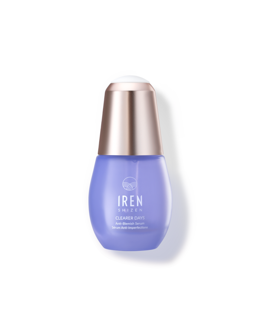 A blue bottle of skincare serum with a metallic cap, labeled "CLEARER DAYS Anti-Blemish Serum" by IREN Shizen, provides an effective niacinamide serum and acne treatment solution.