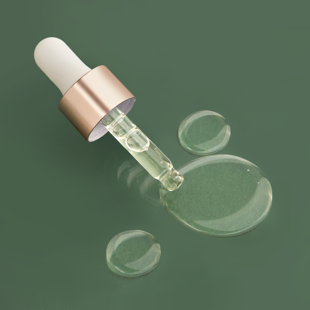 An IREN Shizen glass bottle with a DROP OF DEW Moisturizing Facial Oil on a green surface, showcasing Japanese skincare.